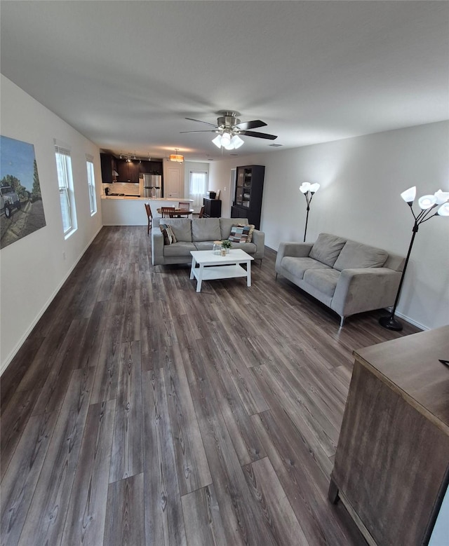 2415 Russell St, Crandall, TX 75114 - living room featuring dark wood-style floors, a ceiling fan, and baseboards