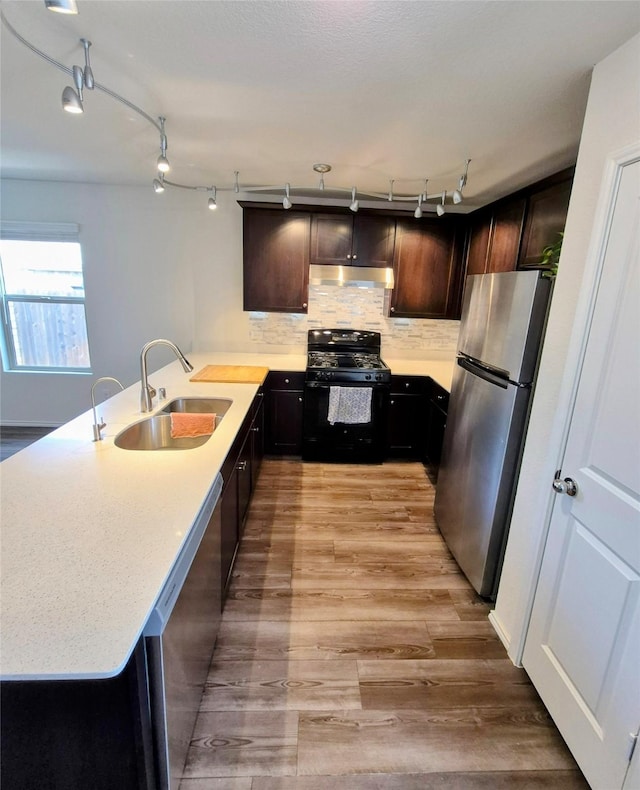 2415 Russell St, Crandall, TX 75114 - kitchen with stainless steel appliances, a sink, under cabinet range hood, a peninsula, and track lighting