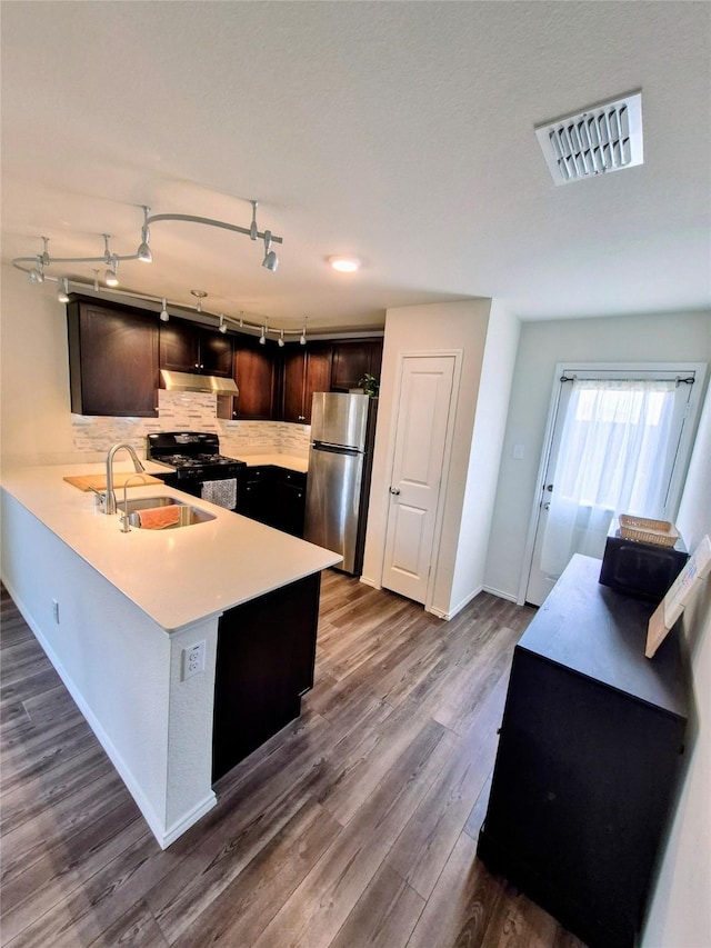 2415 Russell St, Crandall, TX 75114 - kitchen featuring freestanding refrigerator, black gas stove, under cabinet range hood, a sink, and light countertops
