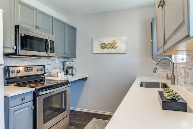 4833 Harper Dr, Mesquite, TX 75150 - kitchen with stainless steel appliances, a sink, dark wood-style flooring, decorative backsplash, and light countertops
