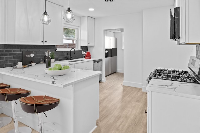 1007 N Cottonwood Dr, Richardson, TX 75080 - kitchen featuring a sink, a peninsula, stainless steel appliances, white cabinetry, and recessed lighting