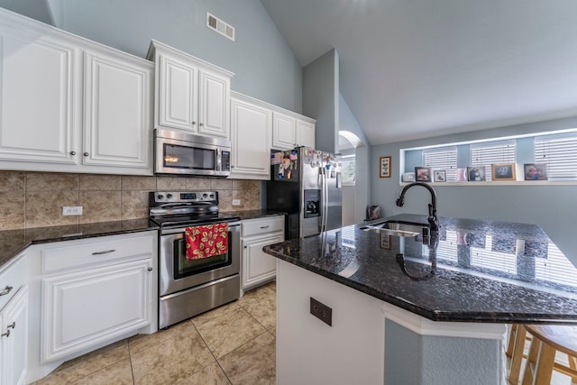6606 Morning Dew Dr, Midlothian, TX 76065 - kitchen featuring appliances with stainless steel finishes, a sink, decorative backsplash, white cabinetry, and light tile patterned floors