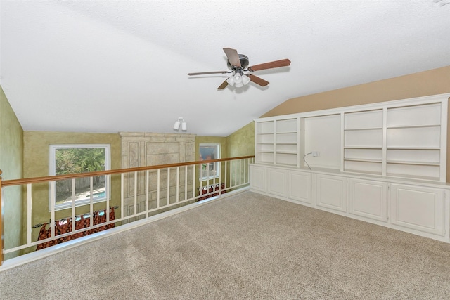 unfurnished room with ceiling fan, vaulted ceiling, and carpet