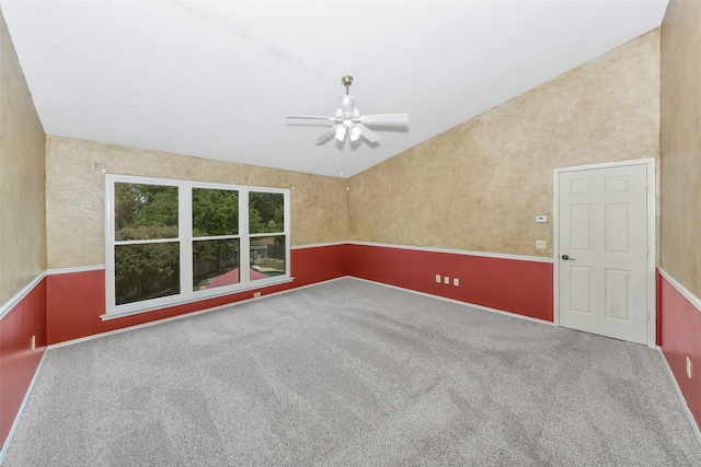 carpeted empty room featuring ceiling fan and lofted ceiling