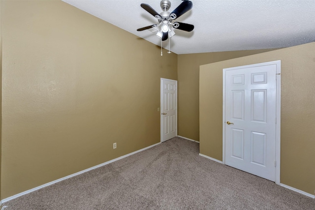 unfurnished bedroom with carpet flooring, baseboards, lofted ceiling, and a ceiling fan