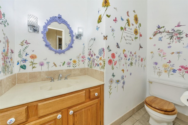 half bathroom featuring tile patterned flooring, toilet, vanity, and baseboards