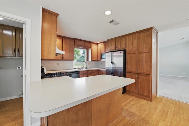 815 Middle Run, Duncanville, TX 75137 - kitchen featuring appliances with stainless steel finishes, light countertops, light wood-type flooring, a peninsula, and recessed lighting