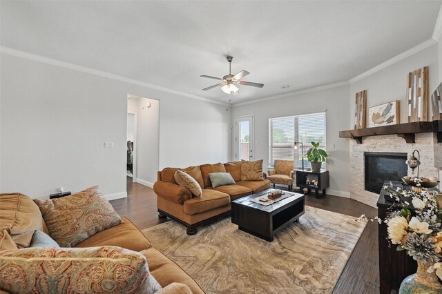 7205 York St, North Richland Hills, TX 76180 - living room featuring crown molding, wood finished floors, a ceiling fan, baseboards, and a stone fireplace