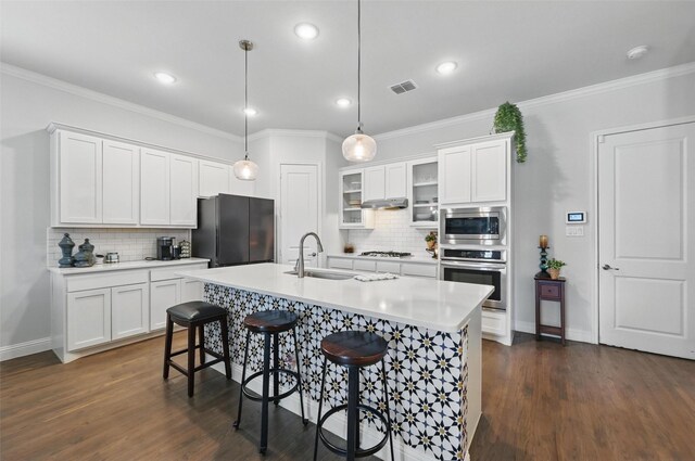 7205 York St, North Richland Hills, TX 76180 - kitchen featuring stainless steel appliances, a sink, tasteful backsplash, a kitchen island with sink, and ornamental molding