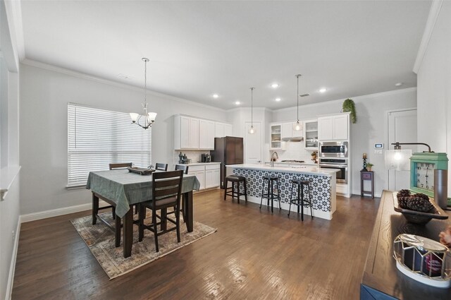 7205 York St, North Richland Hills, TX 76180 - dining room with dark wood-type flooring, recessed lighting, a chandelier, ornamental molding, and baseboards