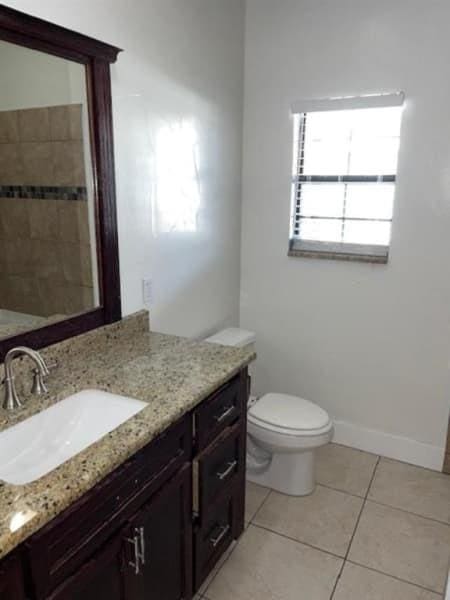 522 Helena St, Dallas, TX 75217 - bathroom with tile patterned flooring, toilet, vanity, and baseboards