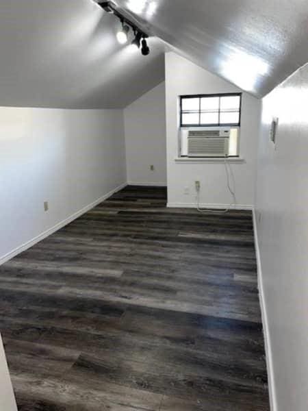522 Helena St, Dallas, TX 75217 - additional living space featuring lofted ceiling, dark wood-style flooring, baseboards, and cooling unit