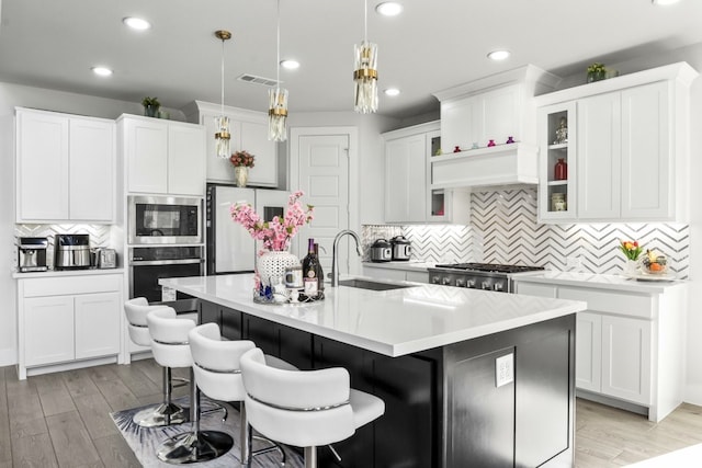 2229 Boboli Ct, Celina, TX 75009 - kitchen with appliances with stainless steel finishes, tasteful backsplash, a sink, a kitchen breakfast bar, and light countertops