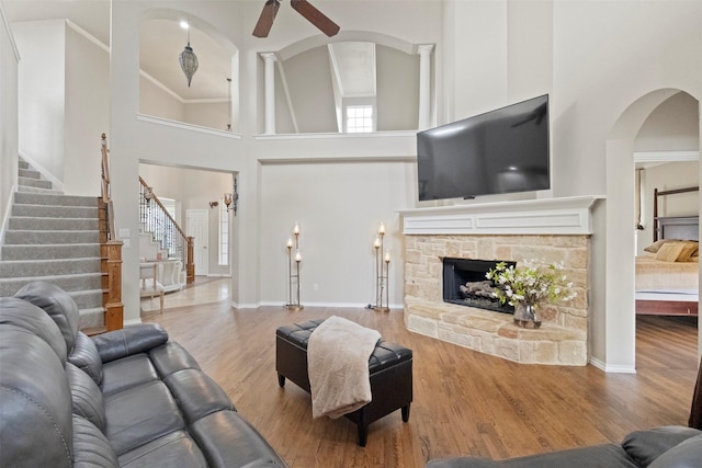 2671 Marshall Dr, Frisco, TX 75033 - living area featuring a towering ceiling, stairs, wood finished floors, arched walkways, and a ceiling fan