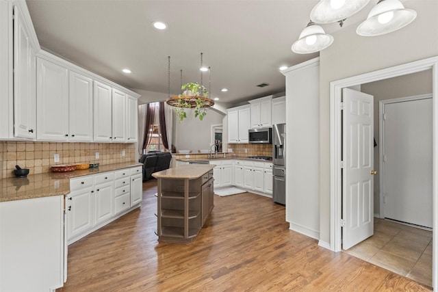2671 Marshall Dr, Frisco, TX 75033 - kitchen with appliances with stainless steel finishes, decorative backsplash, white cabinets, light wood finished floors, and recessed lighting