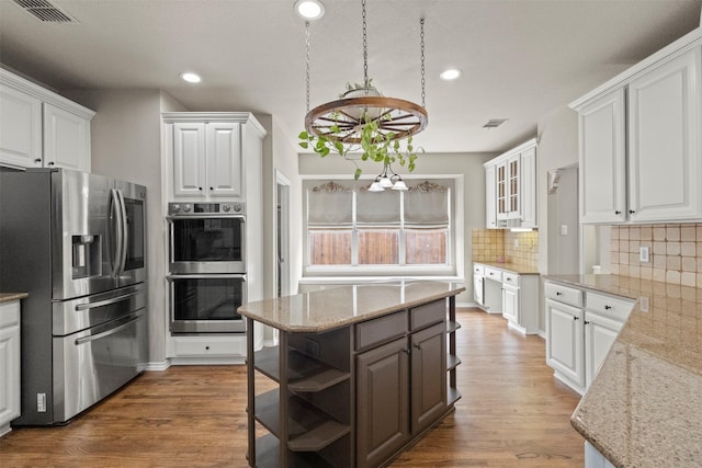 2671 Marshall Dr, Frisco, TX 75033 - kitchen featuring stainless steel appliances, open shelves, white cabinets, tasteful backsplash, and a center island