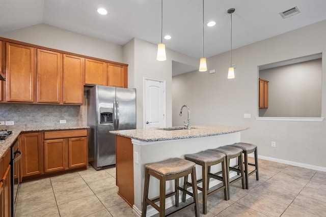 6620 Roaring Crk, Denton, TX 76226 - kitchen featuring stainless steel fridge with ice dispenser, a sink, brown cabinets, light tile patterned flooring, and recessed lighting