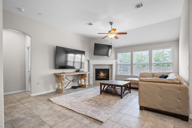 6620 Roaring Crk, Denton, TX 76226 - tiled living area with arched walkways, ceiling fan, a fireplace, and baseboards