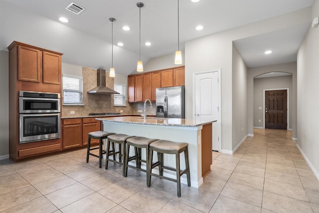 6620 Roaring Crk, Denton, TX 76226 - kitchen featuring wall chimney range hood, appliances with stainless steel finishes, brown cabinetry, and recessed lighting