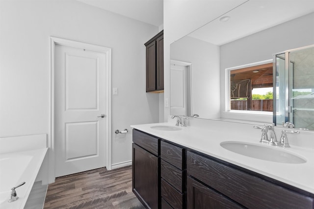 2619 Pinckney Ct, Forney, TX 75126 - full bathroom with double vanity, wood finished floors, a shower with door, and a tub to relax in
