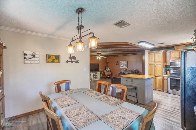 225 Field St, Clyde, TX 79510 - dining room featuring light wood-style floors, a ceiling fan, a textured ceiling, crown molding, and baseboards