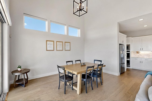 2517 Plum Tree Way, Mckinney, TX 75071 - dining area with light wood finished floors, a chandelier, recessed lighting, baseboards, and a towering ceiling