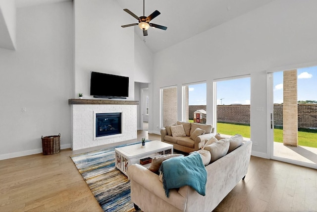 2517 Plum Tree Way, Mckinney, TX 75071 - living room with high vaulted ceiling, wood finished floors, baseboards, a glass covered fireplace, and ceiling fan