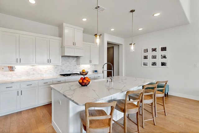 2517 Plum Tree Way, Mckinney, TX 75071 - kitchen with light wood finished floors, white cabinets, a kitchen bar, backsplash, and recessed lighting