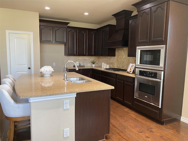 8740 Running River Ln, Fort Worth, TX 76131 - kitchen with appliances with stainless steel finishes, a sink, light stone counters, dark wood-style flooring, and decorative backsplash