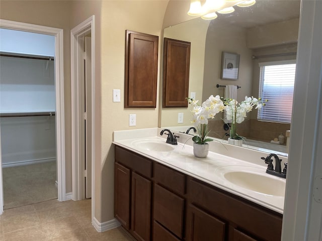 8740 Running River Ln, Fort Worth, TX 76131 - bathroom featuring double vanity, a spacious closet, baseboards, and tile patterned floors