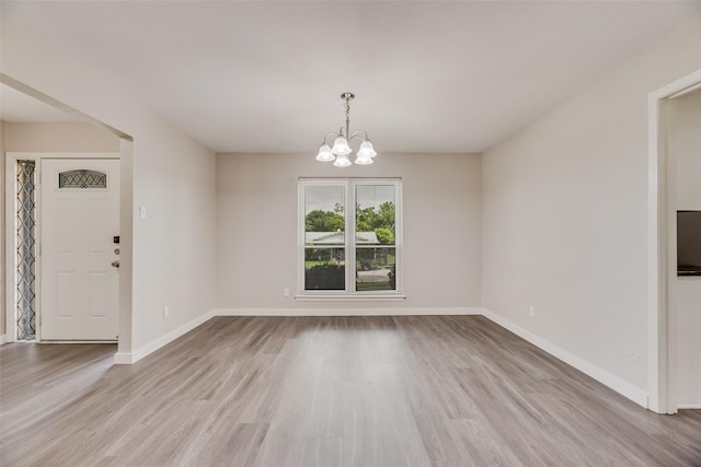 1305 Willow Way, Garland, TX 75043 - unfurnished dining area with wood finished floors, baseboards, and a chandelier