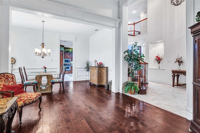 11086 Tenison Ln, Frisco, TX 75033 - foyer featuring wood-type flooring, a chandelier, crown molding, a towering ceiling, and baseboards