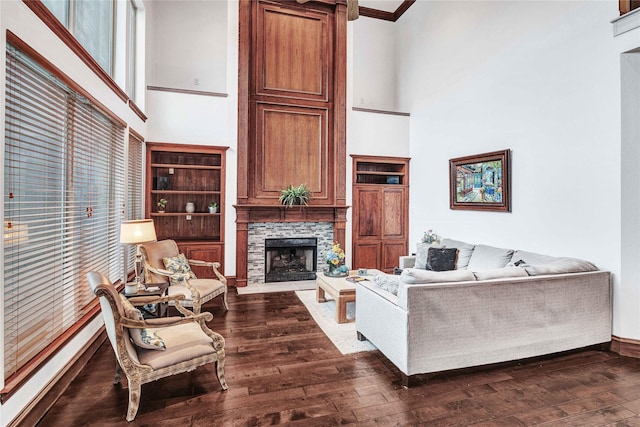 11086 Tenison Ln, Frisco, TX 75033 - living room featuring a high ceiling, a stone fireplace, wood-type flooring, crown molding, and baseboards