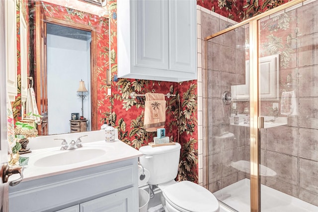 11086 Tenison Ln, Frisco, TX 75033 - bathroom featuring wallpapered walls, a shower stall, vanity, and toilet