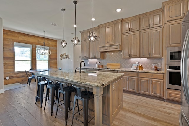 149 Deats Farm Ct, Azle, TX 76020 - kitchen with stainless steel appliances, a sink, light wood-style flooring, a kitchen bar, and light stone counters