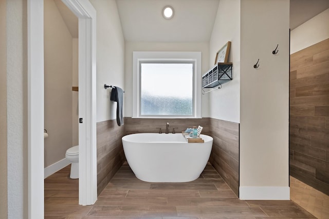 149 Deats Farm Ct, Azle, TX 76020 - full bathroom with tile walls, a soaking tub, toilet, a wainscoted wall, and wood finished floors