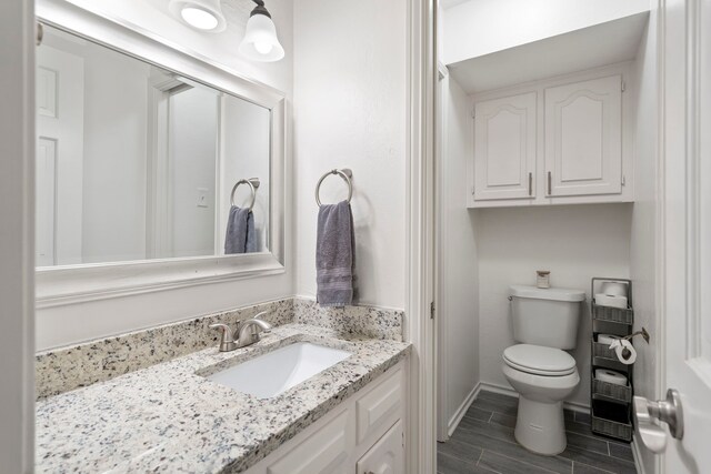 201 Forest Trce, Rockwall, TX 75087 - bathroom featuring toilet, wood tiled floors, vanity, and baseboards