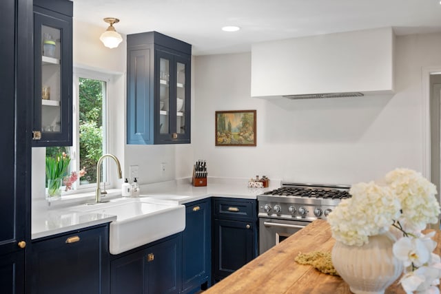 201 Forest Trce, Rockwall, TX 75087 - kitchen featuring stainless steel gas range oven, a sink, blue cabinetry, glass insert cabinets, and extractor fan