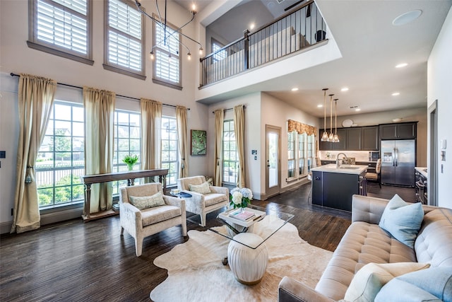 4944 Sage Hill Dr, Carrollton, TX 75010 - living room featuring dark wood-style flooring, a chandelier, baseboards, recessed lighting, and a high ceiling
