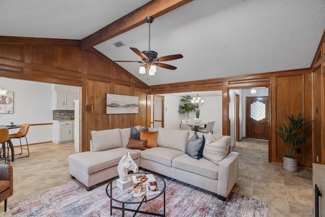 1009 Windmill Ln, Irving, TX 75061 - living room featuring a ceiling fan, wooden walls, a textured ceiling, and a chandelier