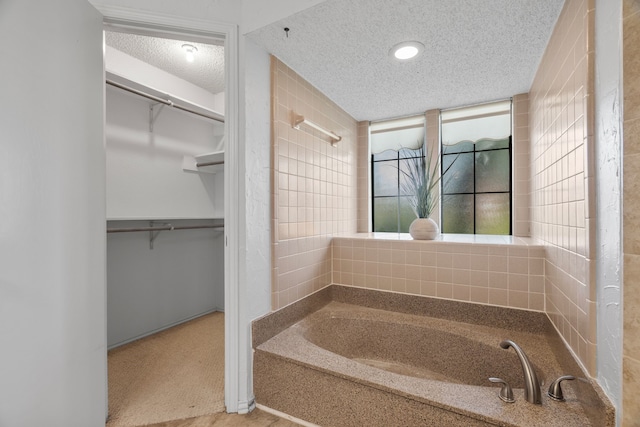 1009 Windmill Ln, Irving, TX 75061 - full bathroom featuring a textured ceiling, a garden tub, and a spacious closet