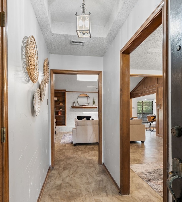 1009 Windmill Ln, Irving, TX 75061 - hall featuring a textured ceiling, baseboards, and tile patterned floors