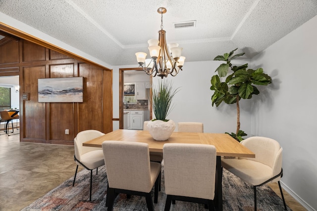 1009 Windmill Ln, Irving, TX 75061 - dining area featuring a textured ceiling, a chandelier, and a raised ceiling