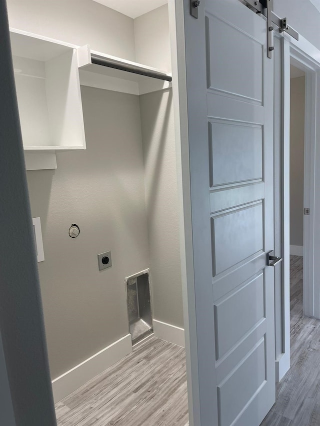 1315 W Gandy St, Denison, TX 75020 - washroom featuring hookup for an electric dryer, baseboards, wood finished floors, and a barn door