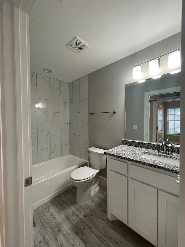 1315 W Gandy St, Denison, TX 75020 - full bath featuring wood finished floors, toilet, vanity, shower / tub combination, and baseboards
