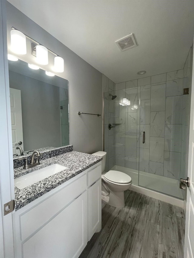 1315 W Gandy St, Denison, TX 75020 - full bathroom with wood finished floors, a shower stall, toilet, and vanity