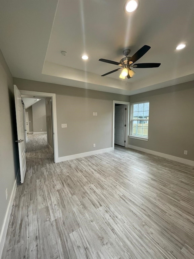 1315 W Gandy St, Denison, TX 75020 - unfurnished room with a ceiling fan, light wood-style flooring, a raised ceiling, baseboards, and recessed lighting