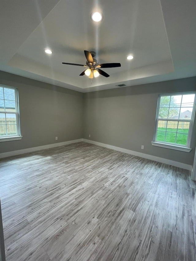 1315 W Gandy St, Denison, TX 75020 - unfurnished room featuring a raised ceiling, wood finished floors, healthy amount of natural light, and recessed lighting