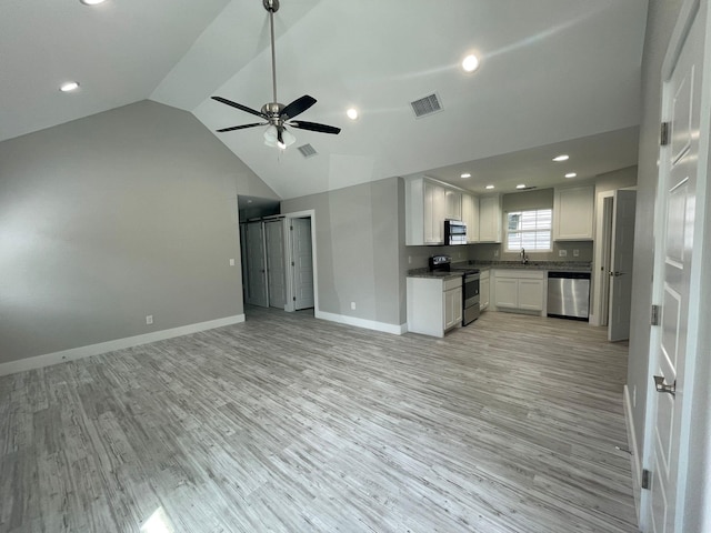1315 W Gandy St, Denison, TX 75020 - unfurnished living room featuring light wood-type flooring, vaulted ceiling, baseboards, a ceiling fan, and a sink