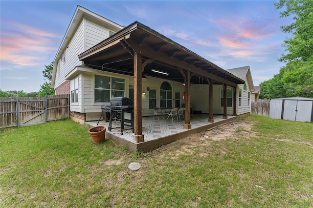 7804 Rampston Pl, Fort Worth, TX 76137 - back of house at dusk with a shed, a patio, an outbuilding, and a gate